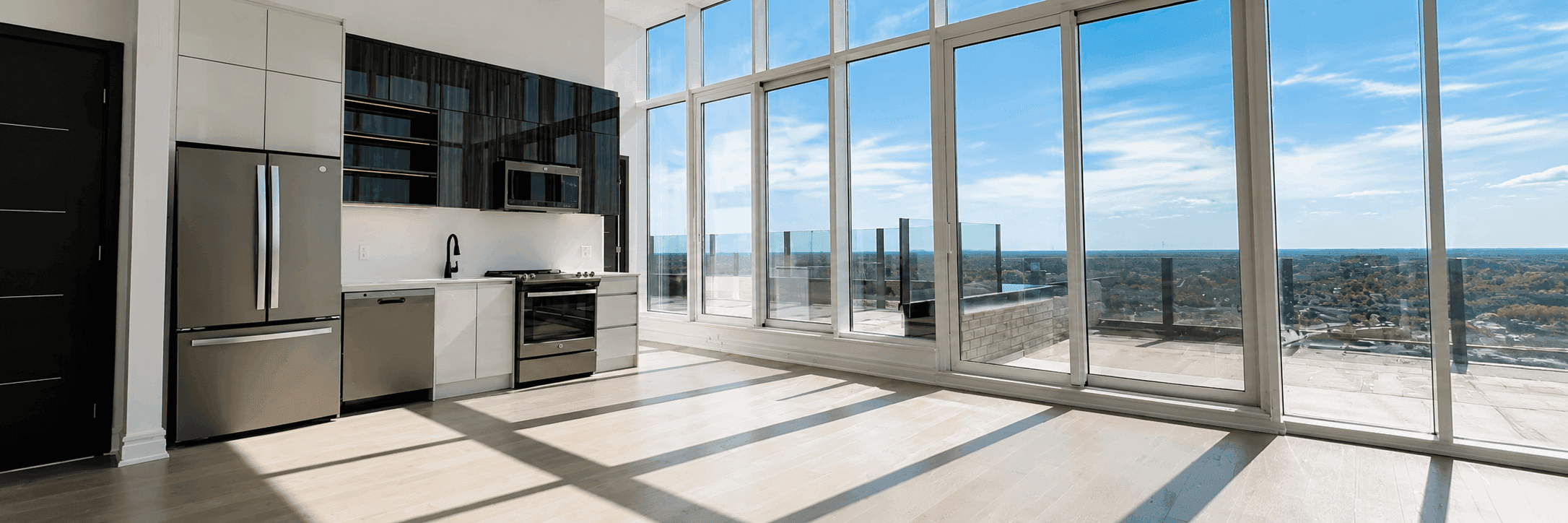 Penthouse kitchen and living area with wraparound glass and terrace access