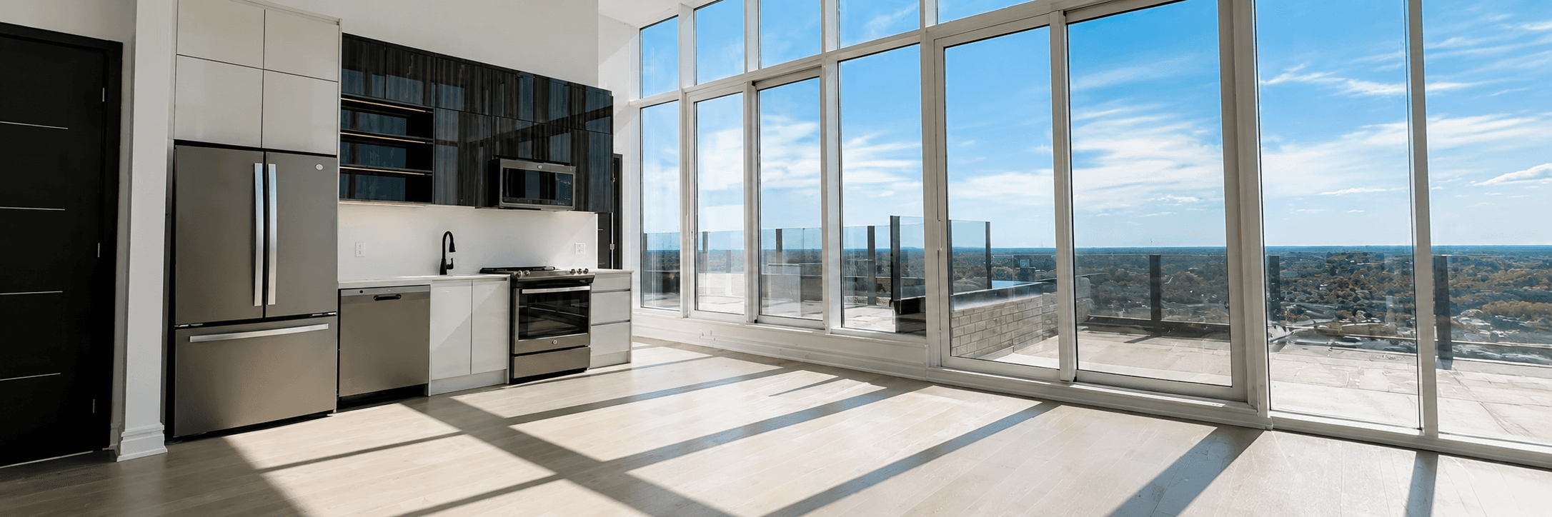 Penthouse kitchen and living area with wraparound glass and terrace access